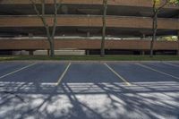 parking garage with three trees in front of it and a fire hydrant on the ground