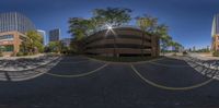 a view from outside of a parking garage, with tall buildings on either side, and a building across the street