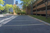 a car park with several parking spaces along with some tall buildings in the background,