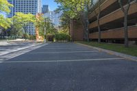 a car park with several parking spaces along with some tall buildings in the background,