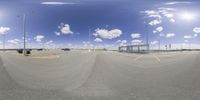 cars parked in a parking lot while seen through a fish eye lens by an airport