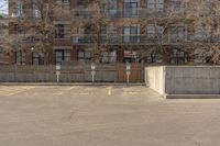 a parking lot with a concrete building in the background and no people sitting on benches on it