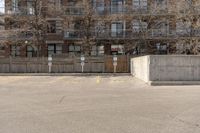 a parking lot with a concrete building in the background and no people sitting on benches on it