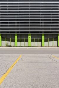 a view of a building with a parking lot in front of it that has green doors and shutters