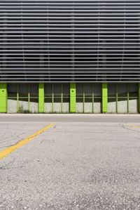 a view of a building with a parking lot in front of it that has green doors and shutters