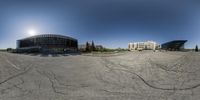 an empty parking lot with lots of cars parked and several other buildings behind it in a city