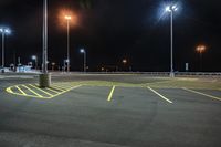 a parking lot at night lit with street lights and an empty parking space in the background