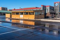 a big parking lot with several buildings and a few signs that say burgers on the building