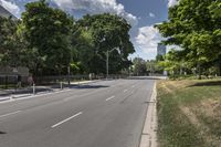 a man walking down a city street on a skateboard ramp and trees in the distance