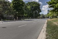 a man walking down a city street on a skateboard ramp and trees in the distance