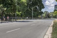 a man walking down a city street on a skateboard ramp and trees in the distance