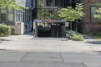 a car driving past an entrance to a building with multiple doors and bushes next to the sidewalk