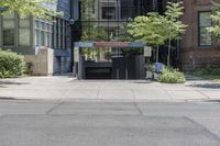 a car driving past an entrance to a building with multiple doors and bushes next to the sidewalk