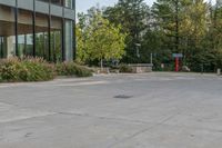 a walkway with plants, trees and a fire hydrant in front of the building