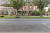 street view of the beautiful home in a city park area with trees on either side