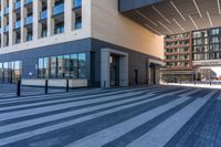 an empty street with a large glass building and a city sidewalk in the background with pedestrians