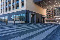 an empty street with a large glass building and a city sidewalk in the background with pedestrians