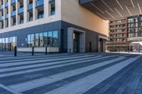 an empty street with a large glass building and a city sidewalk in the background with pedestrians