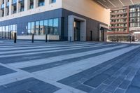 an empty street with a large glass building and a city sidewalk in the background with pedestrians