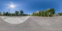 a 360 - view of a street showing trees and buildings in the background with a man on a skateboard