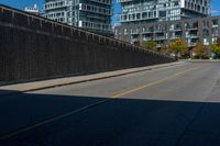 a sidewalk with two buildings on the other side of it that is empty and not in use