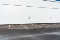 a white building with white lines painted on it in the parking lot near a street