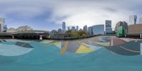 this is an image of an outdoor skate park in the city that's empty and has many skating boards to the side