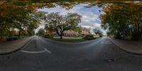 a fish eye view of a street through a fisheye lens with some leaves on the ground