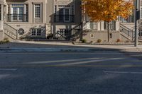 a black fire hydrant in front of a beige building with trees on the side of the road