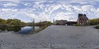 a reflection image showing a road with cobblestones and houses in the background, taken from a 360 camera