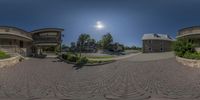 a fish eye lens photograph of a building with three entrances and a path between two streets