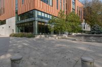 a courtyard with concrete steps next to trees and building entrance on a sunny day outside