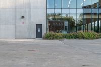 the red fire hydrant is sitting on a sidewalk by the building that has a glass window