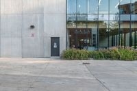 the red fire hydrant is sitting on a sidewalk by the building that has a glass window