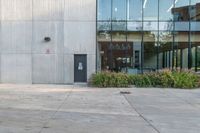 the red fire hydrant is sitting on a sidewalk by the building that has a glass window