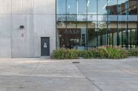 the red fire hydrant is sitting on a sidewalk by the building that has a glass window