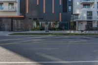 a grey, black and orange building is behind a street sign on the corner of the street