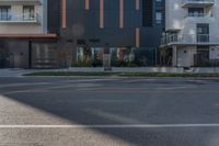 a grey, black and orange building is behind a street sign on the corner of the street