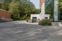 the walkway is made up of cement slabs and plants next to the building with large glass windows