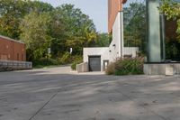 the walkway is made up of cement slabs and plants next to the building with large glass windows