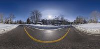 a snowy mountain is shown through a fisheye lens of the street in the foreground