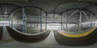 two curved walls inside a terminal building that has stairs on each side and railings on the other