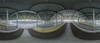 a wide angle shot taken through the fisheye lens of a train station, with multiple seats below