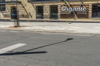 a pole with two lights next to a building on the corner of a street intersection