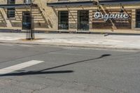 a pole with two lights next to a building on the corner of a street intersection