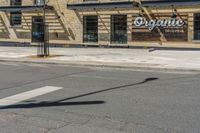 a pole with two lights next to a building on the corner of a street intersection