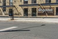 a pole with two lights next to a building on the corner of a street intersection