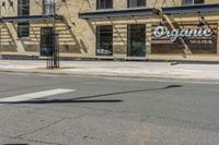 a pole with two lights next to a building on the corner of a street intersection