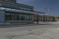 the side of the building features an enclosed glass wall and columns, along with some flags