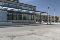 the side of the building features an enclosed glass wall and columns, along with some flags